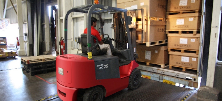 forklift lifting wooden crates in a warehouse